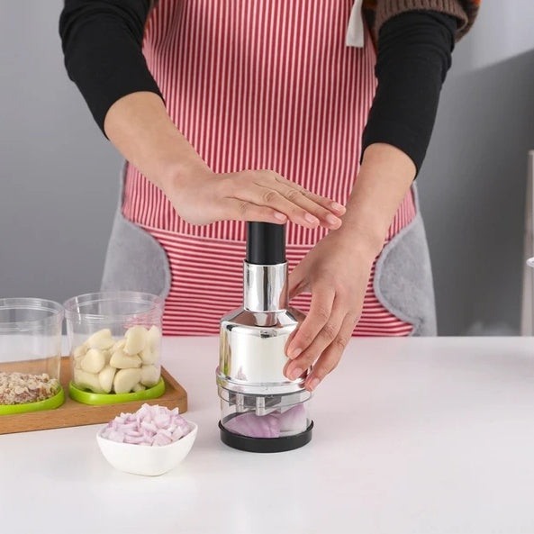 A manual food chopper in use while preparing vegetables